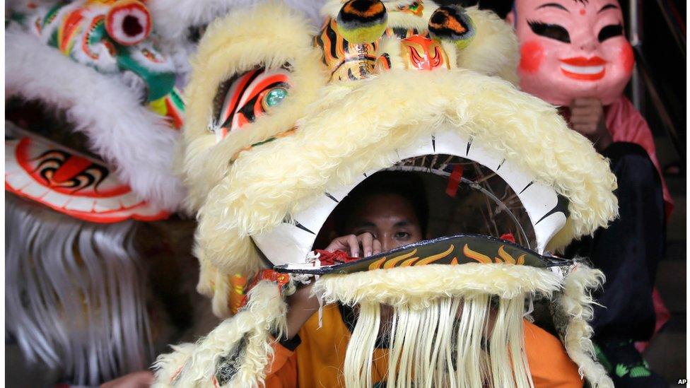 Dragon dancers take a break after a performance outside a business premises on the eve of Chinese new year, in Manila's Chinatown district of Binondo