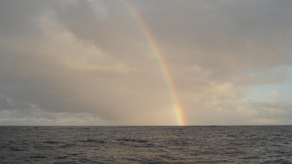 Rainbow ending in the sea