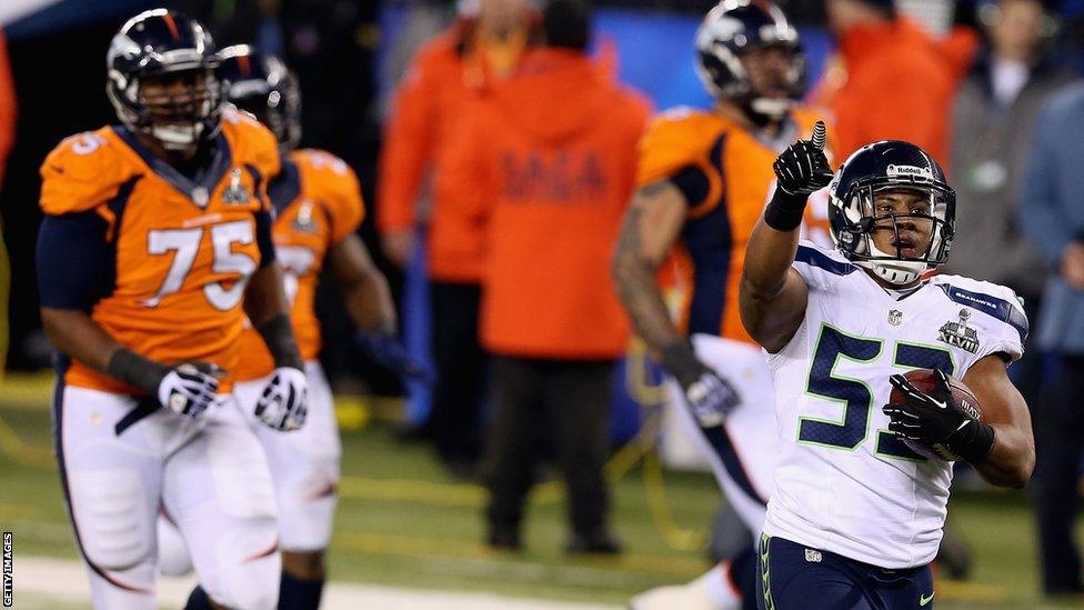 Seattle linebacker Malcolm Smith (right) returns Denver quarterback Peyton Manning's second interception of the night for a touchdown