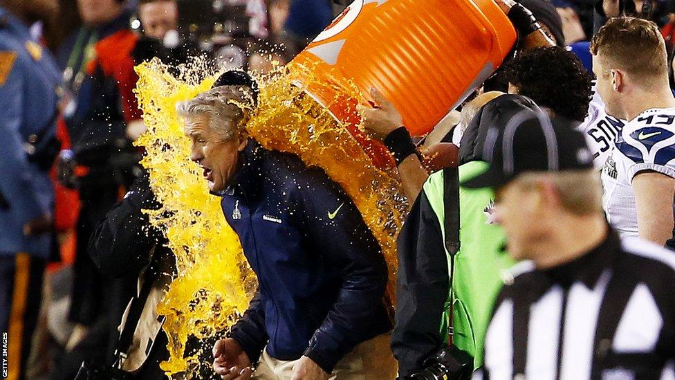 Pete Carroll, head coach of the Seattle Seahawks, is soaked in soft drink as part of the traditional Super Bowl celebrations