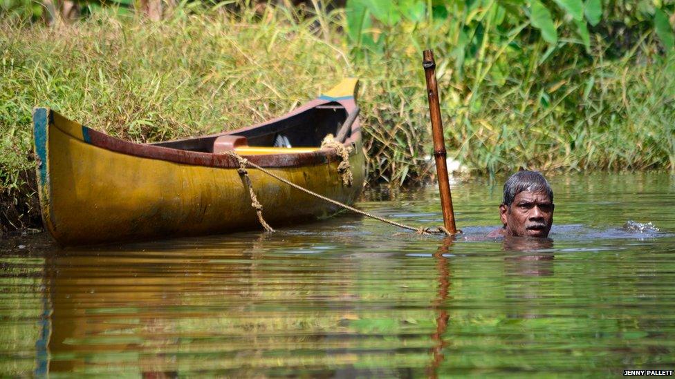 A man fishing for river mussels in Kerala