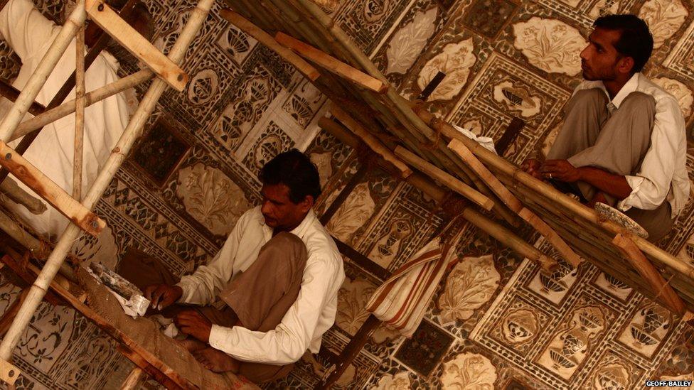 Three workers restoring a part of the Taj Mahal