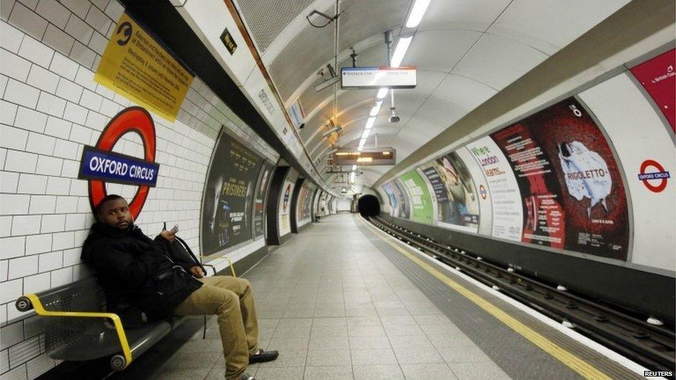 A passenger waits on an empty platform at Oxford Circus Underground station