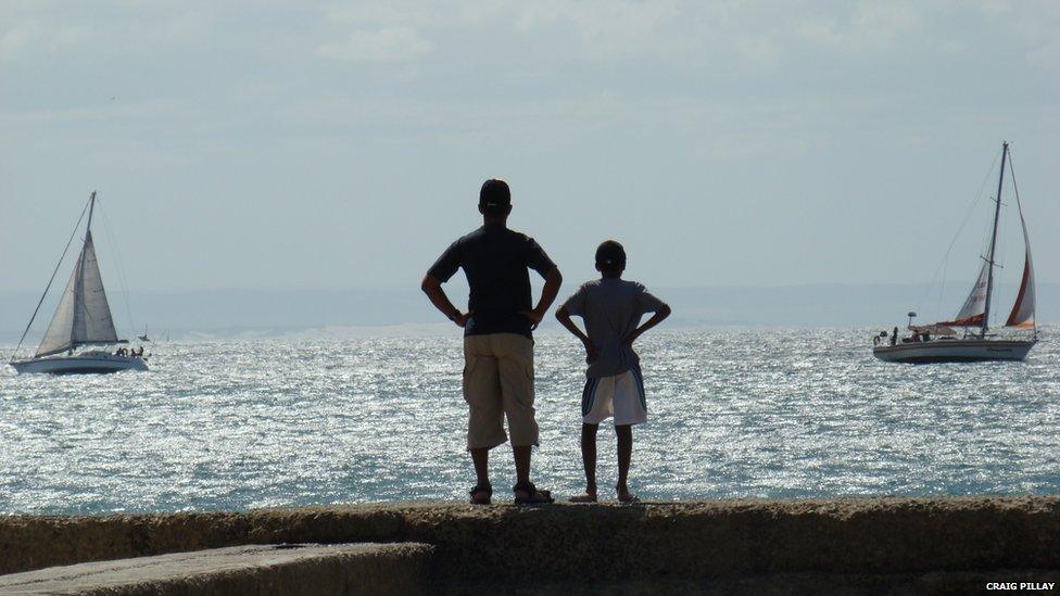 Craig Pillay in Port Elizabeth, South Africa with his son in front of the sea