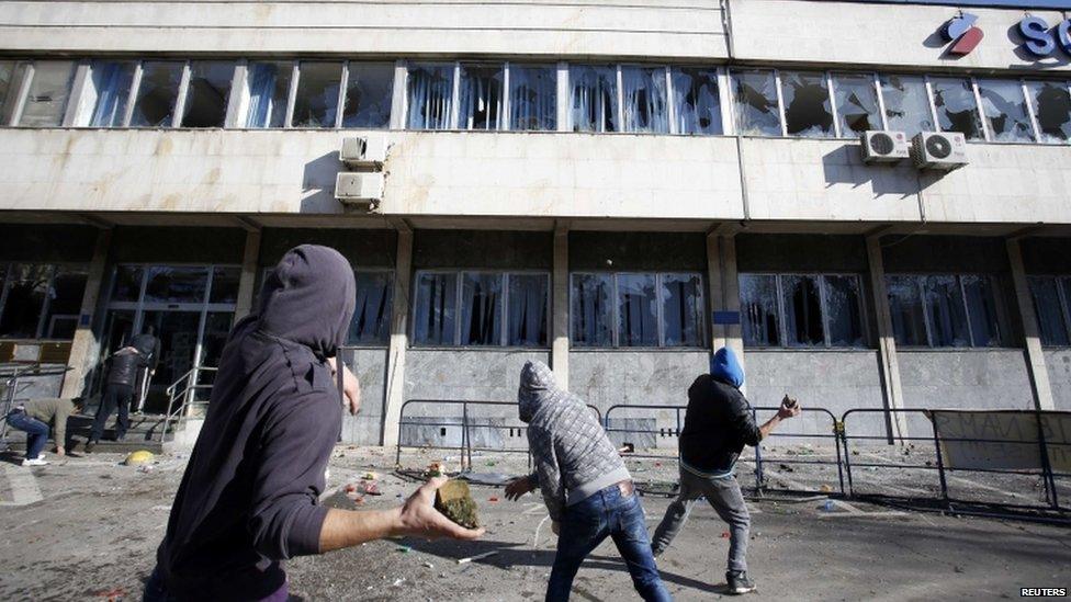 Protesters are throwing rocks at a government building in Tuzla (7 February 2014)