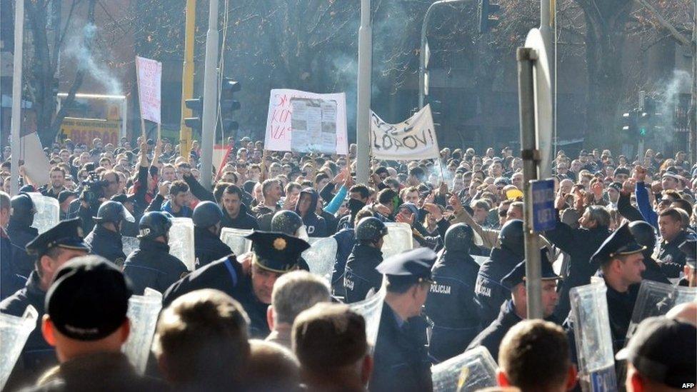 Police stand in front of protesters in the Bosnian town of Tuzla (7 February 2014)