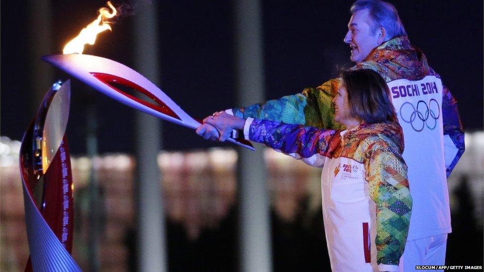 Irina Rodnina (L) and Vladislav Tretyak light the Olympic cauldron.