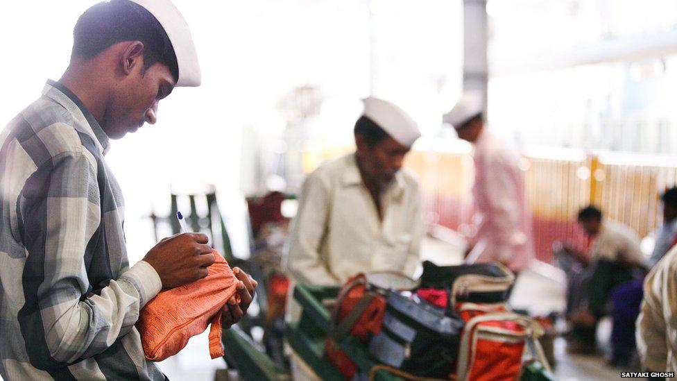 Dabbawalas sort the tins into groups depending on their destination.