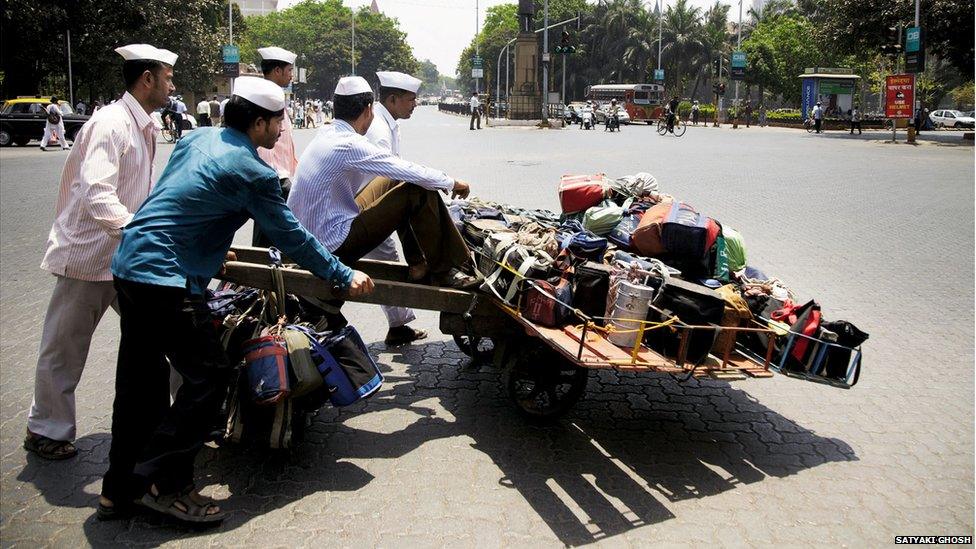 Dabbawalas waiting outside a railway station to transfer tiffin tins for delivery