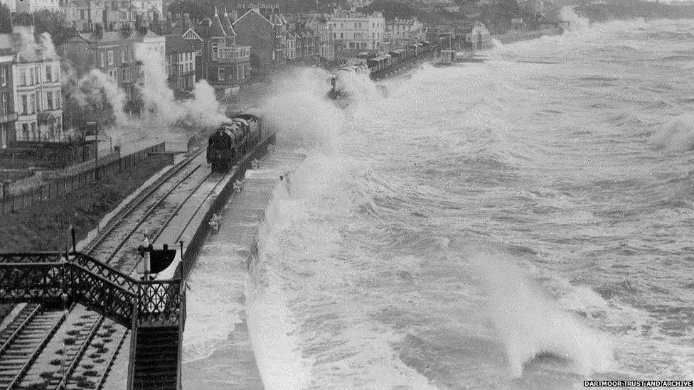 Waves crash over another train travelling through Dawlish