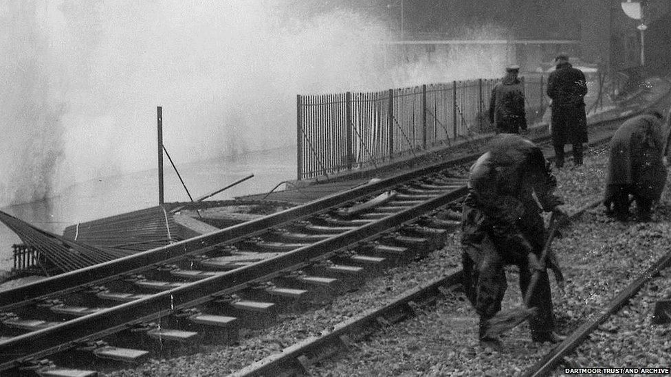 Railway workers clear rubble on the line at Dawlish