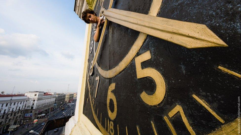 Kirill Vselensky popping his head out of a huge clock face in Minsk in Belarus.