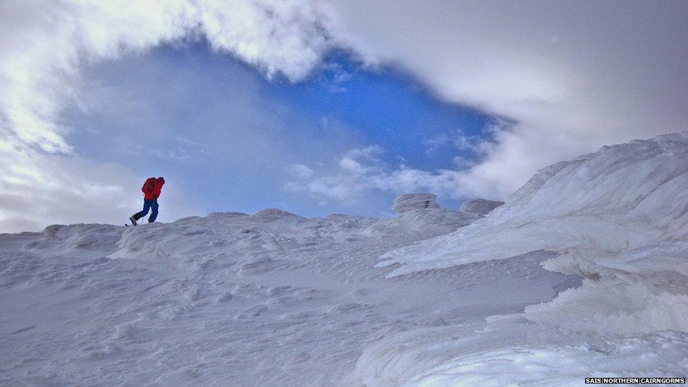 A walker in the Northern Cairngorms with fingers of rime ice in the foreground