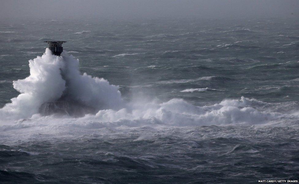 Storm waves crash over the Longships Lighthouse just off Lands End