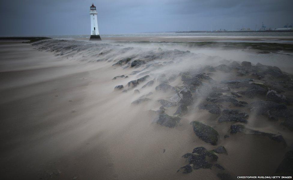 A miniature sandstorm blows across the breakwater next to the Perch Rock lighthouse on in New Brighton, United Kingdom