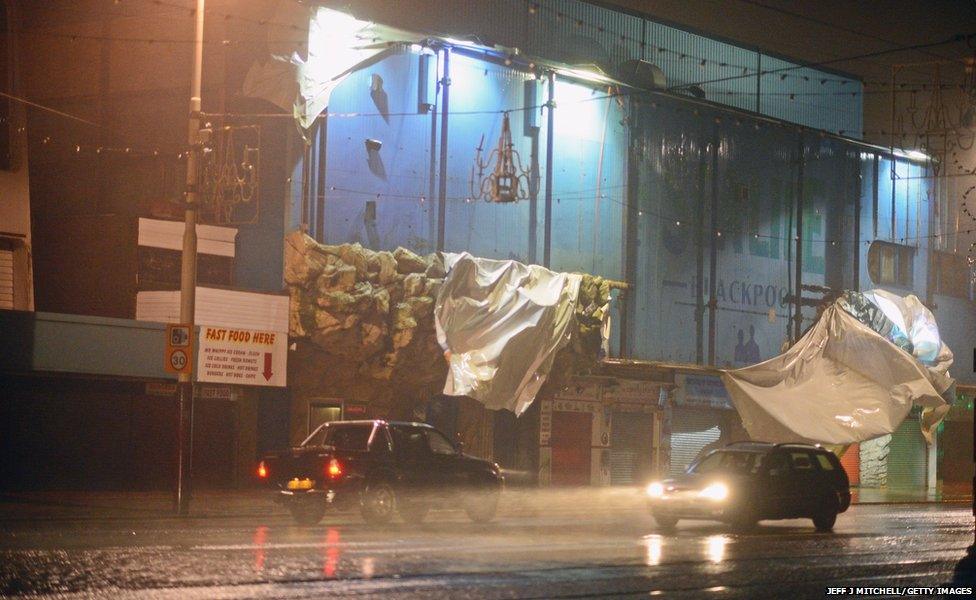 Traffic makes its way past a damaged building at Blackpool Promenade