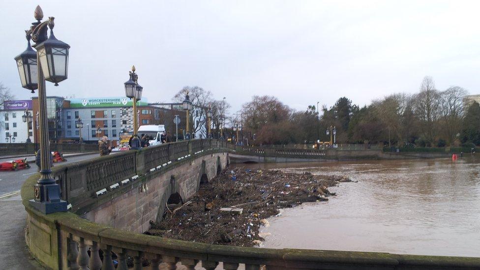 Debris trapped by floodwater against a bridge in the centre of Worcester