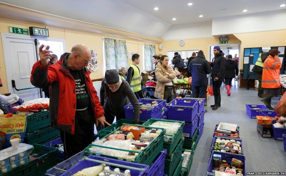 Volunteers at St Pauls Church in Egham, Surrey, separate items donated for people affected by severe flooding in the area