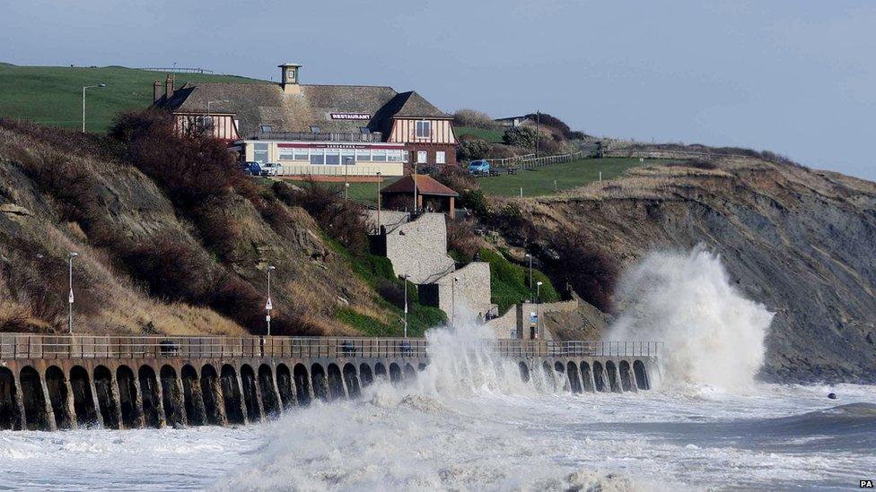 Waves break below the East Cliff Pavillion in Folkestone during high tide.