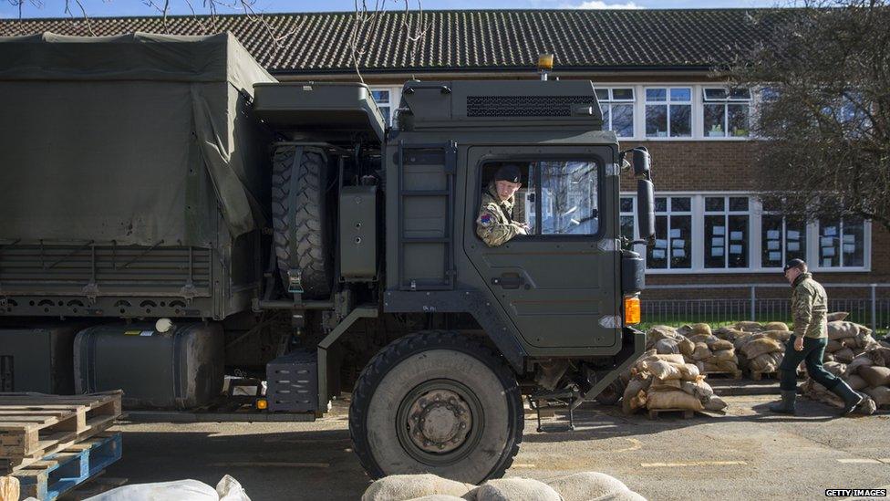 Soldiers from the 1st Regiment Royal Horse Artillery collect sandbags filled by volunteers in Staines, England