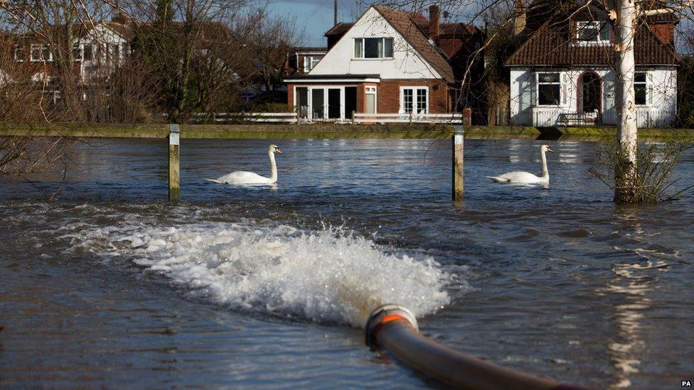 Surrey Fire and Rescue Service use a high volume pump to remove water from a housing estate in Staines-upon-Thames