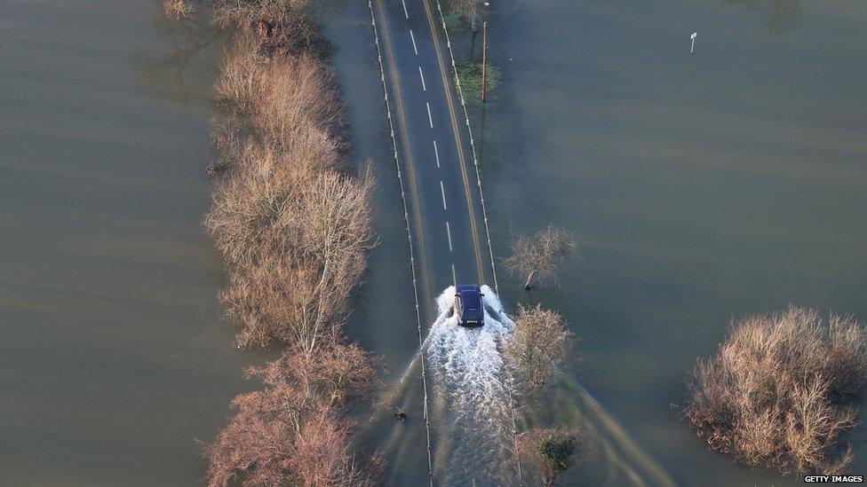 A four wheel drive car drives through flood water in Laleham, England