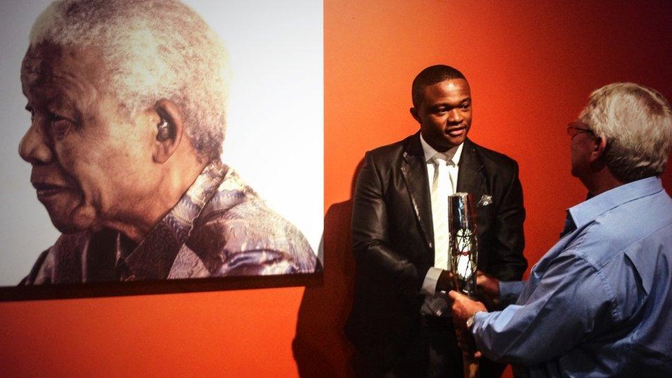 The Queen's Baton held by Luvuyo Mandela, great-grandson of Nelson Mandela, at the Nelson Mandela Foundation’s Centre of Memory, in Johannesburg.