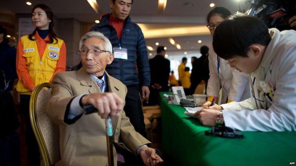 A man selected to attend the family reunions between North and South Koreans is checked by medical staff after arriving at the Hanwha resort in the eastern port city of Sockcho on 19 February 2014