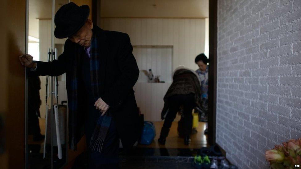 North Korean-born Kim Se-rim (L) leaves his house in Seoul as he prepares to make his way to a reunion of families from North and South Korea separated by the war, on 19 February 2014