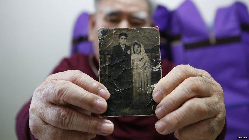 Jang Choon, who has been selected as one of 82 participants of the reunion ceremony this Thursday, poses for photographs with a picture of his youngest brother Jang Ha-choon whom he will meet at a reunion ceremony, at his house in Namyangju, east of Seoul on 19 February 2014