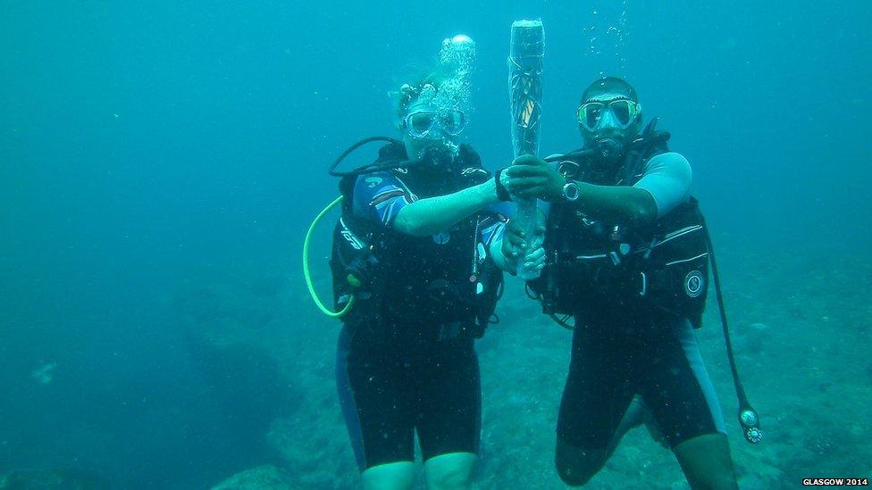 The baton goes underwater in the Seychelles held by British High Commissioner Lindsay Skoll.