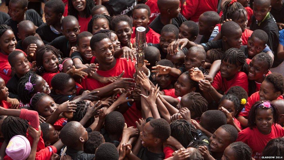 Enthusiastic children reach for the Queen’s baton in Matola, Mozambique.