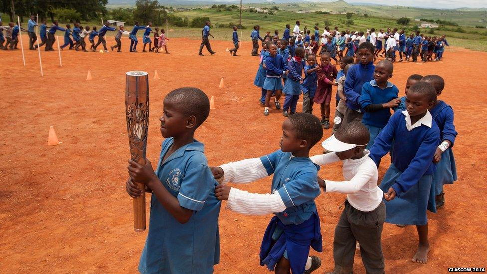 The Queen's Baton carried in a conga-like relay by the school children of the Ngwazini community, Swaziland.