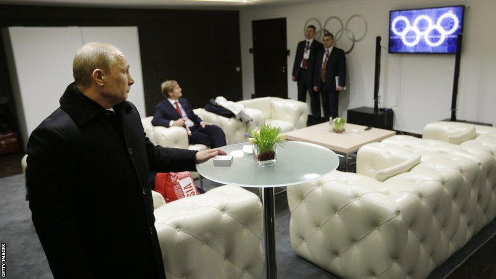 SOCHI, RUSSIA - FEBRUARY 07: Russian President Vladimir Putin waits in the presidential lounge to be introduced at the opening ceremony of the Sochi 2014 Winter Olympics as a television screen displays five Olympic rings at the Fisht Olympic Stadium on February 7, 2014 in Sochi, Russia.