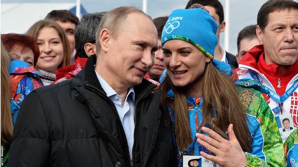 Russian President Vladimir Putin (left) listens to Russian pole vault champion and Olympic village mayor Yelena Isinbayeva at the Olympic village in Sochi on February 5, 2014, two days ahead of the opening ceremony.