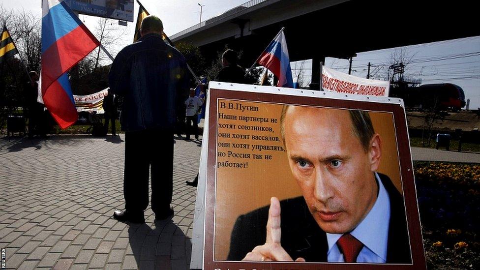 A poster of Russian Vladimir Putin reading "For Motherland, for Russia, for Sovereignty" at a pro-government demonstration in Sochi.