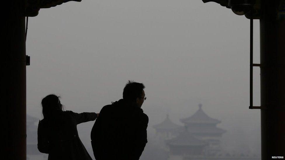 Visitors are silhouetted against thick smog on the top of Jingshan Park near the Forbidden City in Beijing on 24 February 2014