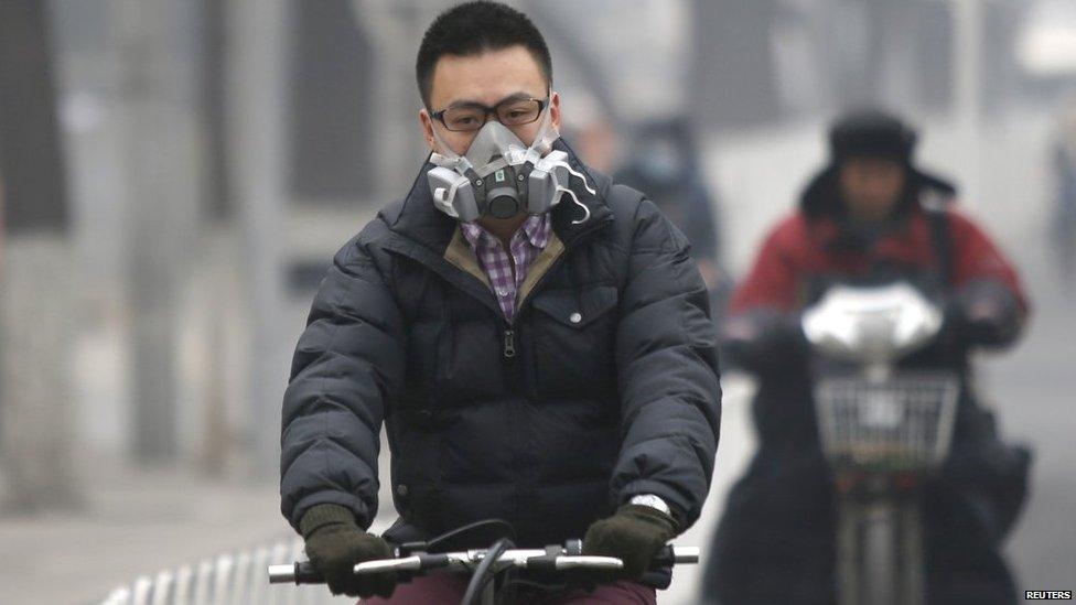 A man wearing a mask rides a bicycle in Beijing 24 February 2014