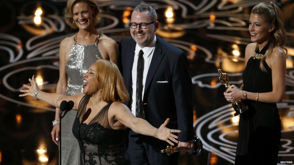 Darlene Love sings as Morgan Neville and Caitrin Rogers look on as they accept the Oscar for best documentary feature for 20 Feet from Stardom