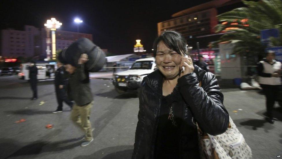 A woman reacts at the crime scene outside Kunming railway station on Saturday 1 March 2014