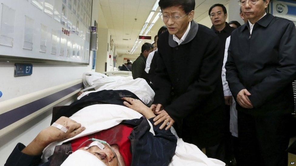 In this photo provided by China's Xinhua News Agency, China's politburo member Meng Jianzhu, second left, visits the wounded who was injured in a knife attack, at No. 1 People's Hospital in Kunming, capital of southwest China's Yunnan Province, Sunday, 2 March 2014