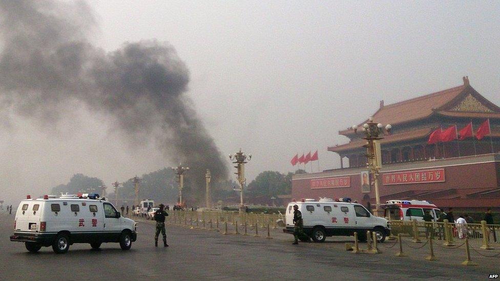 In this file picture taken on 28 October 2013, police cars block off the roads leading into Tiananmen Square as smoke rises into the air after a vehicle crashed in front of Tiananmen Gate in Beijing.