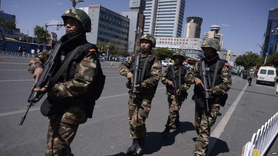 Chinese policemen patrol a street near the railway station in Kunming, southwest China's Yunnan province on 2 March 2014