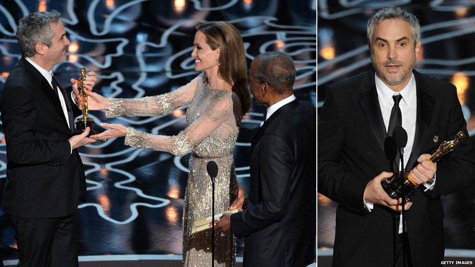 Director Alfonso Cuaron accepts the best director Oscar from Angelina Jolie and Sidney Poitier