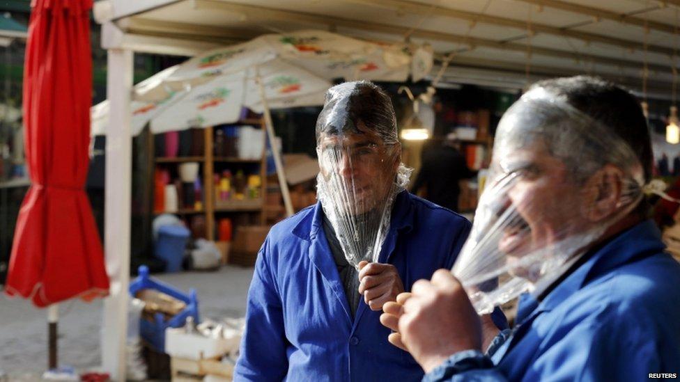 Men cover their heads in cling film to protect themselves from tear gas in Ankara (12 March 2014)