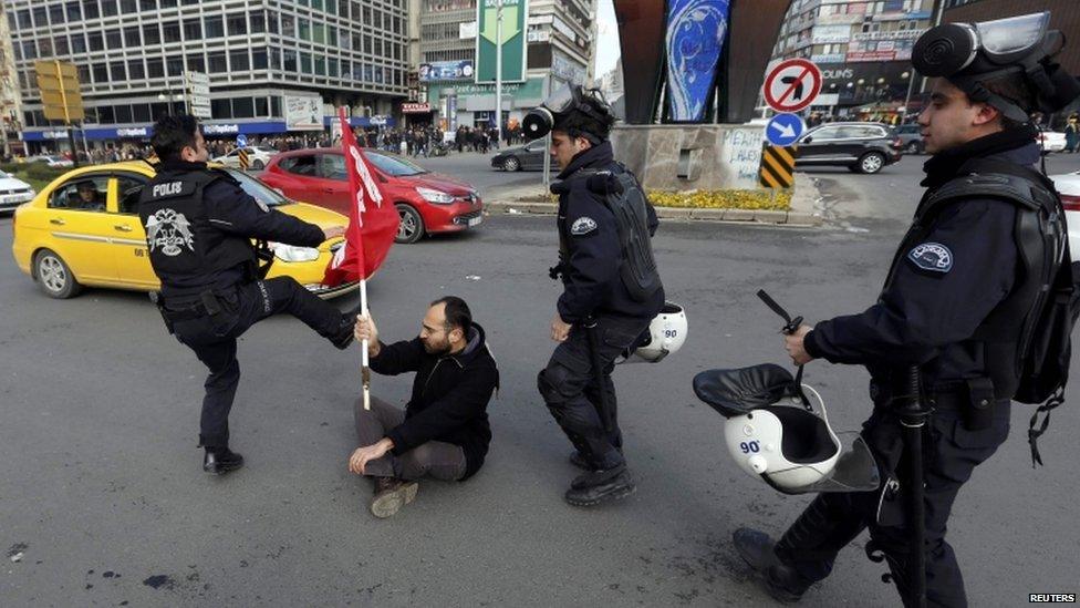 Police officer kicks the flag of an anti-government protester Ankara (12 March 2014)