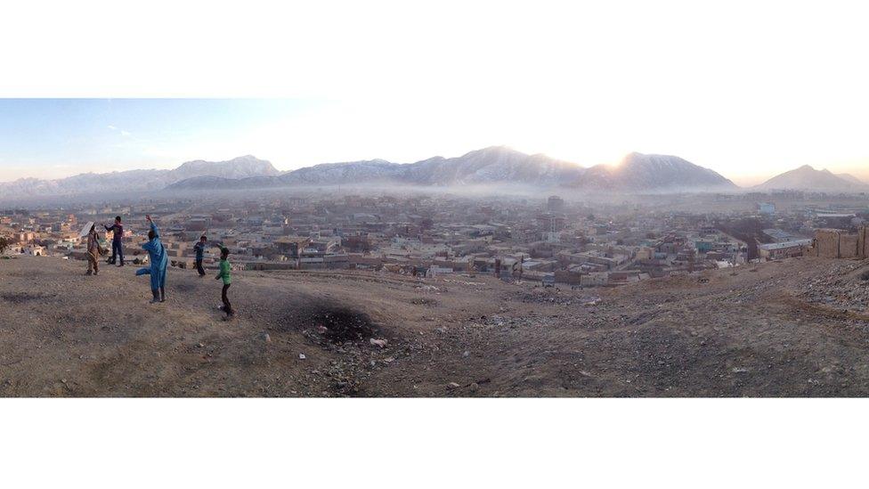 Children playing on a hill overlooking the city