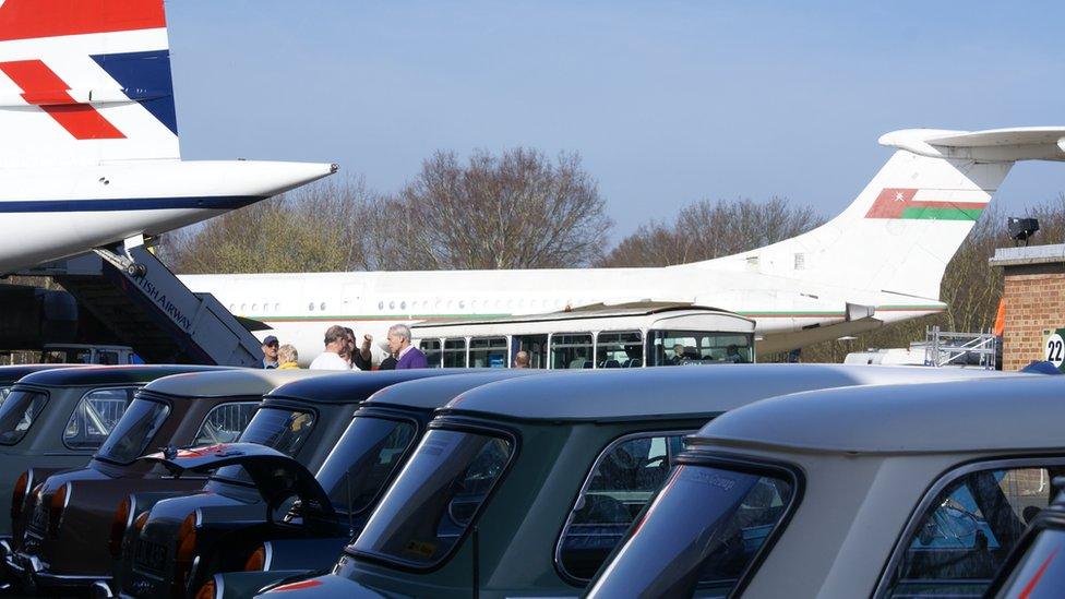 Cars in the shadow of display aircraft at Brooklands Mini Day 2013