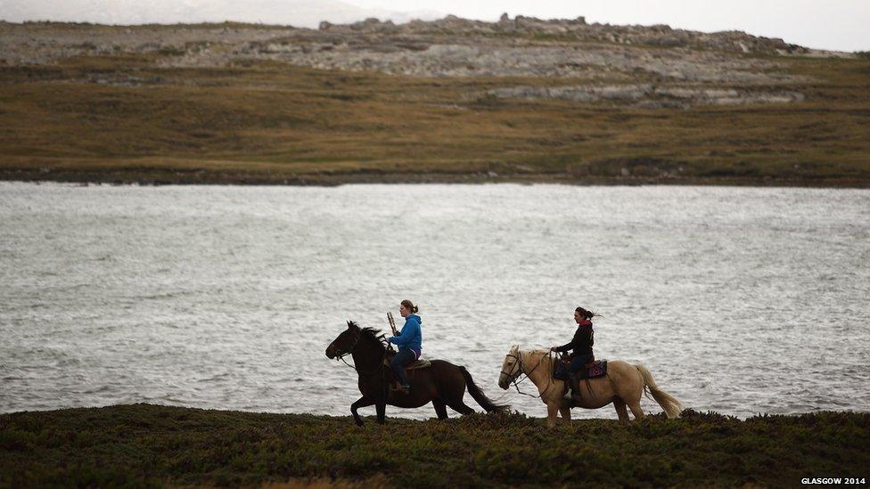 Reba Peck riding Spitfire (left) rides with the Queen's Baton with Holly Williams riding Dixie (right) in Falkland Islands.