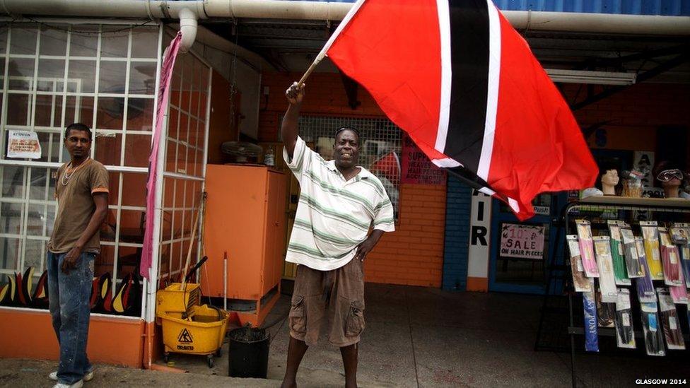 A man shows his patriotic support for the Queen’s Baton Relay by waving a large national flag in Port of Spain, Trinidad.